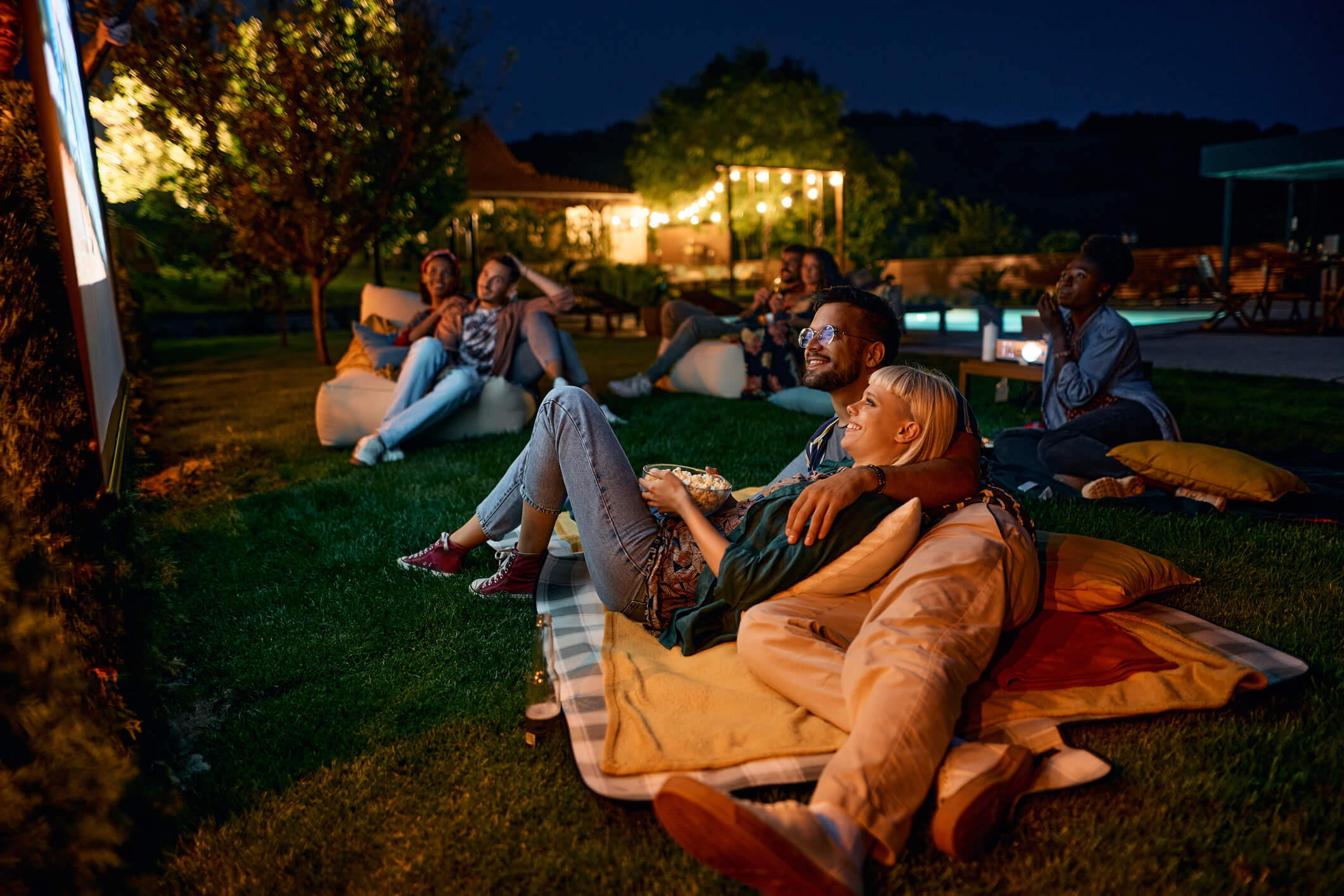 a backyard movie night with blankets and a projector