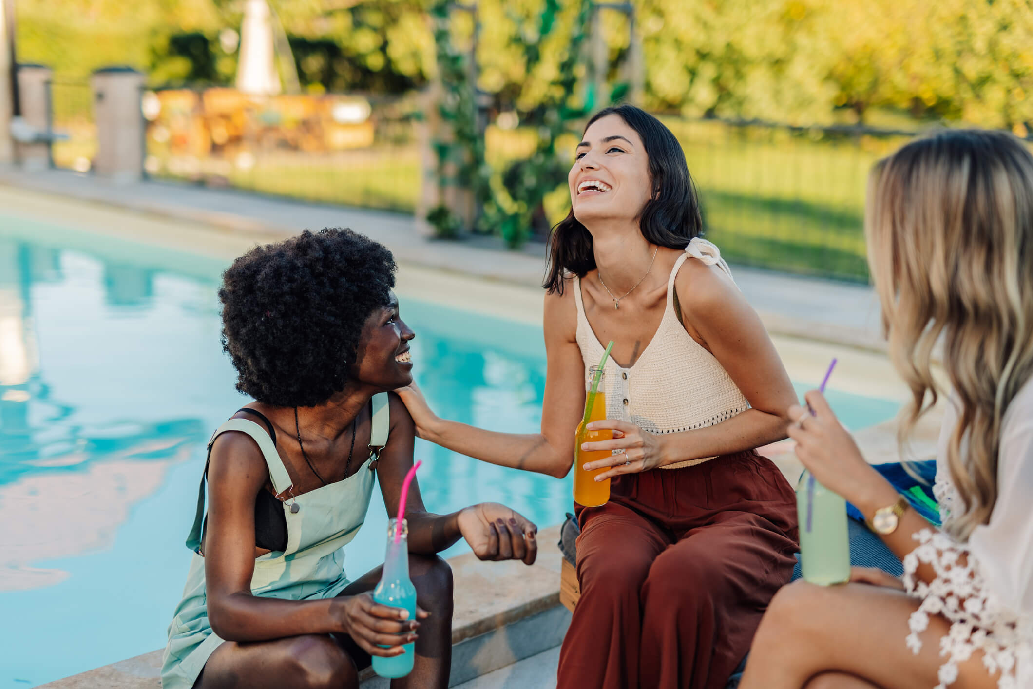 a group of friends drinking beverages at a backyard pool party