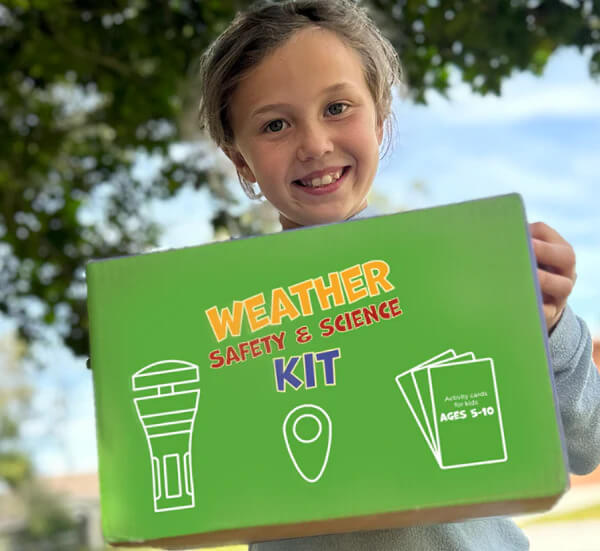 a kid holding up the Tempest Weather Safety Science Kit